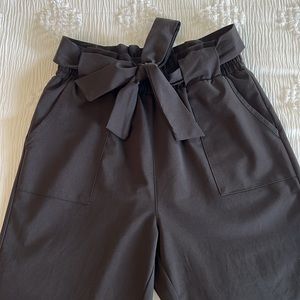 Paper bag waste, cropped black pants